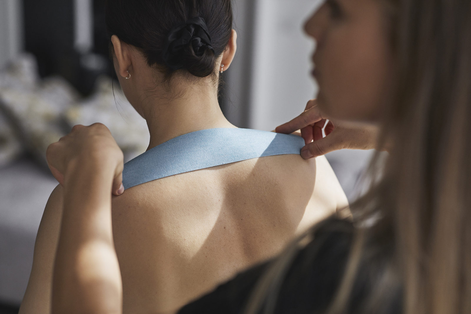 Black tape Kinesio Taping being applied to the back, administered by therapist. Photo Lars Petter Pettersen