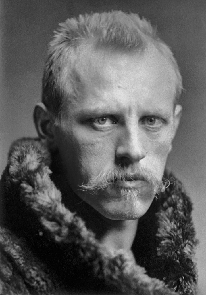 Head and shoulders portrait of Fridtjof Nansen, facing half-right. He has close-cropped hair, a wide, fair moustache and is wearing a heavy fur coat