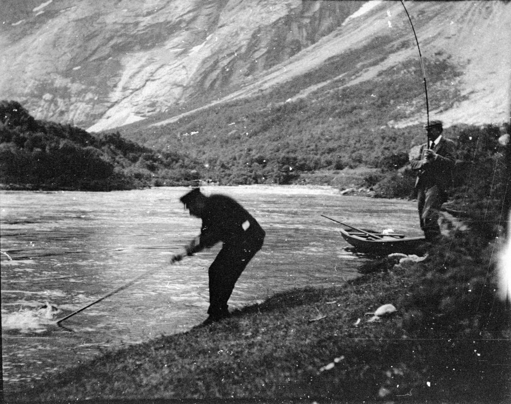 Peder Aak netting a salmon for William Bromsley-Davenport, one of the original Salmon Lords, at Langhølen on the Gaula river, around the turn of the 19th century.