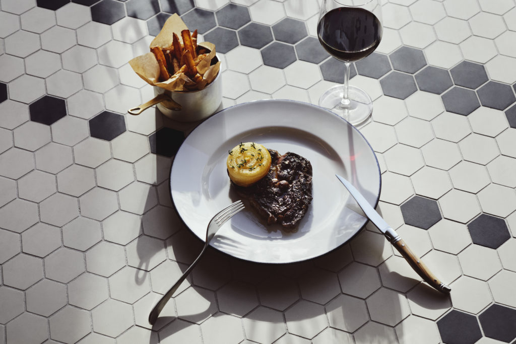 Photo of Entrecôte steak and chips, served at Brasserie Britannia, pictured on tiled floor.