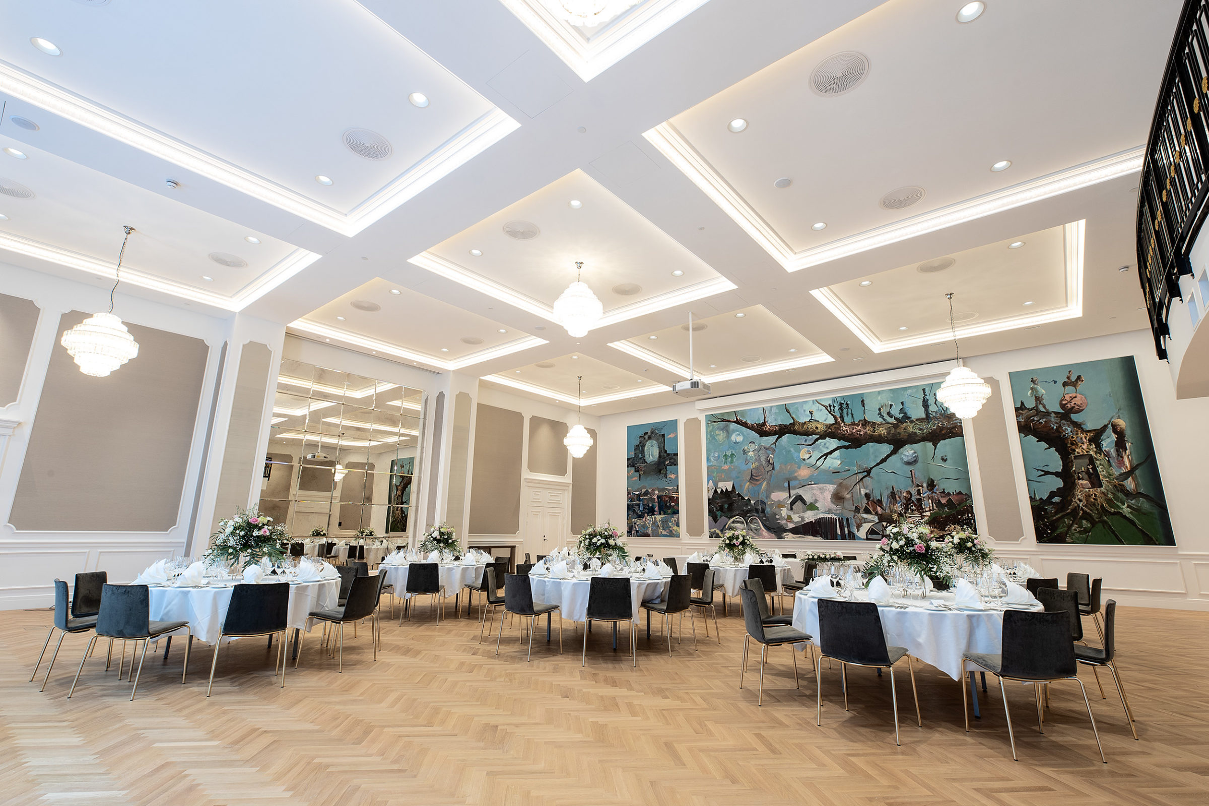 Britannia Hall with round table seatings and beautiful artwork on the walls