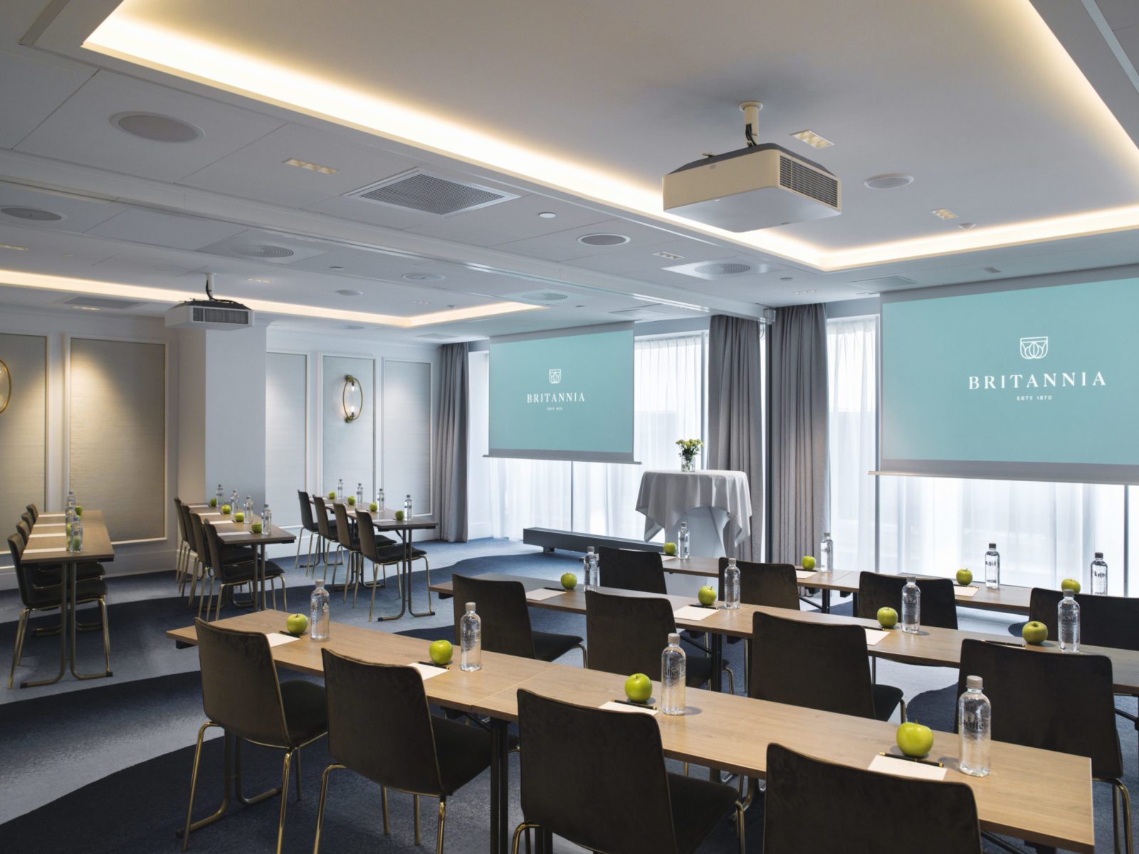 Conference room at Britannia Hotel with 2 big screens and classroom seating