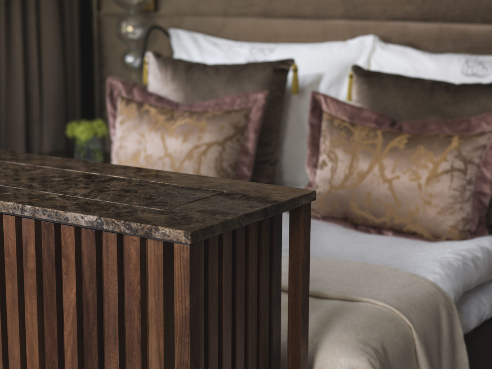 Junior suite på Britannia Hotel, detaljbilde av Hästens seng med kommode i brun marmor i fotenden