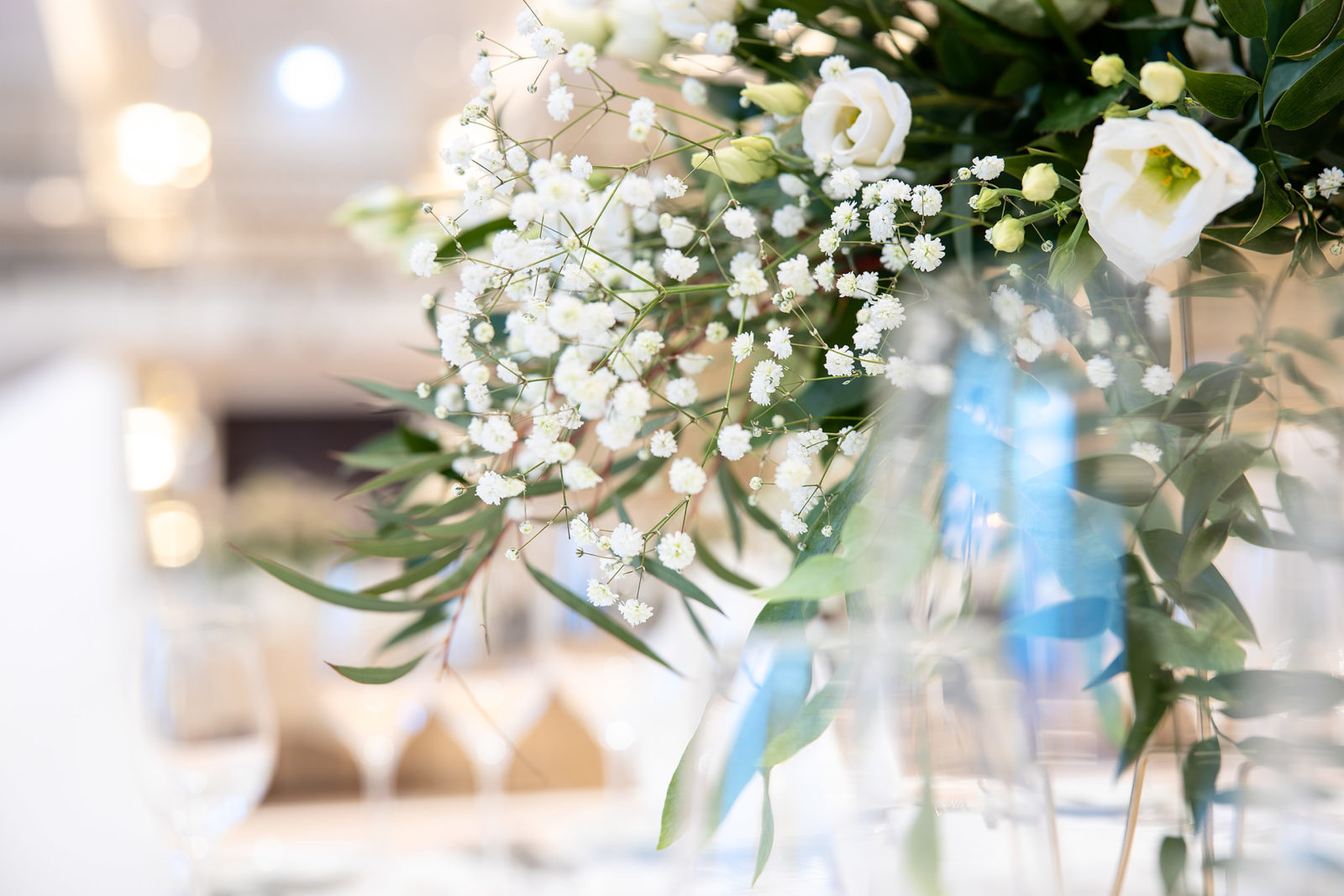 Vakker, hvit blomsterdekorasjon i vase på bordet i bryllup på Britannia Hotel
