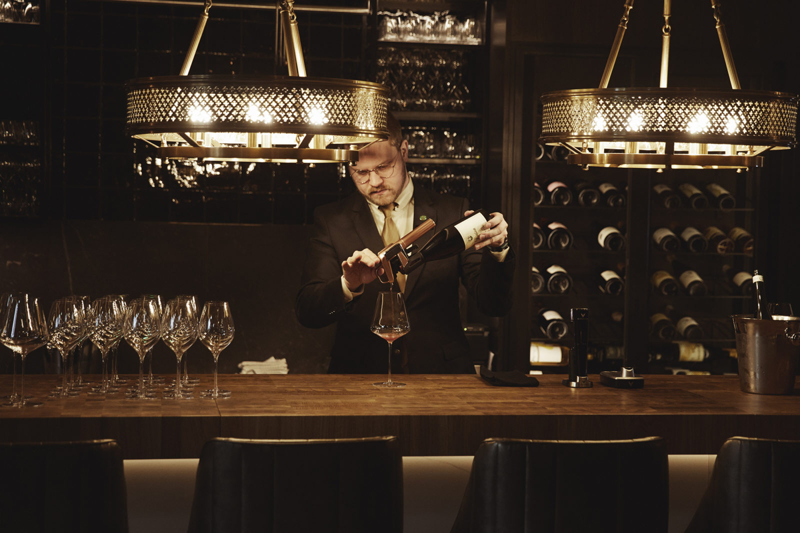 Waiter serving red wine in a glass at the wine cellar