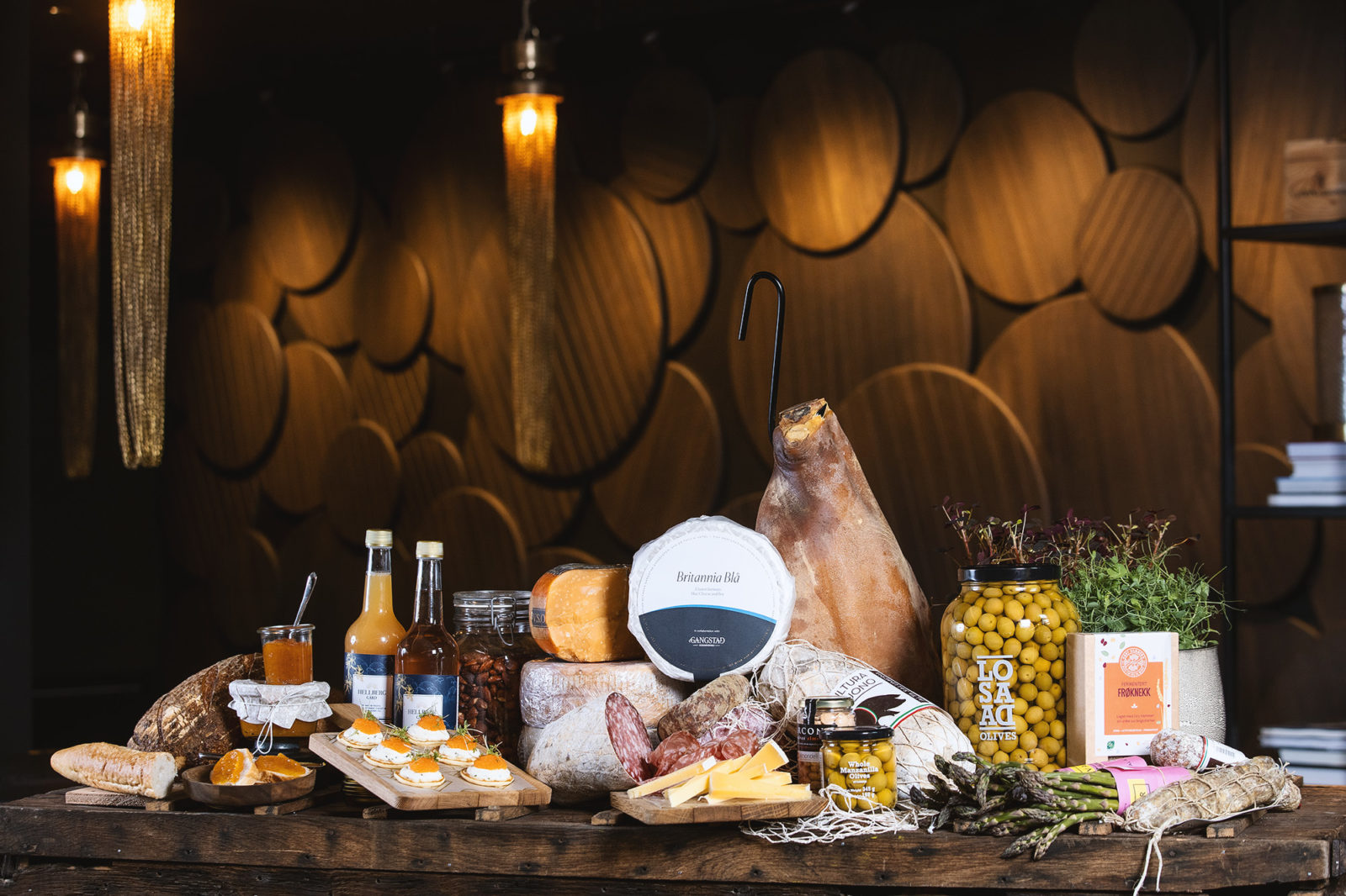 A display of hams, cheeses, blinis, olives and other deli items, as found in the Weekend pack at Vinbaren's Delicatessen, located at Britannia Hotel in Trondheim, Norway.
