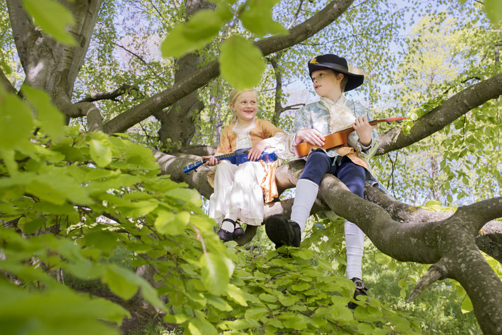 two kids playing an instrument in a tree at Ringve Music Museum