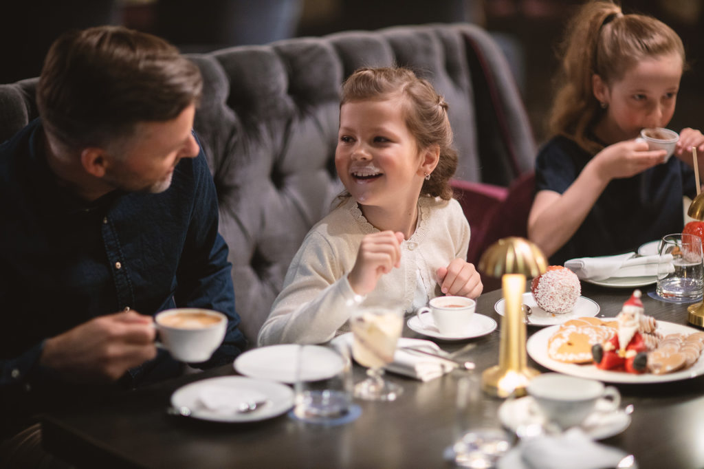 family christmas scene in the bar at Britannia Hotel with father and daughter laughing over coffee and hot chocolate