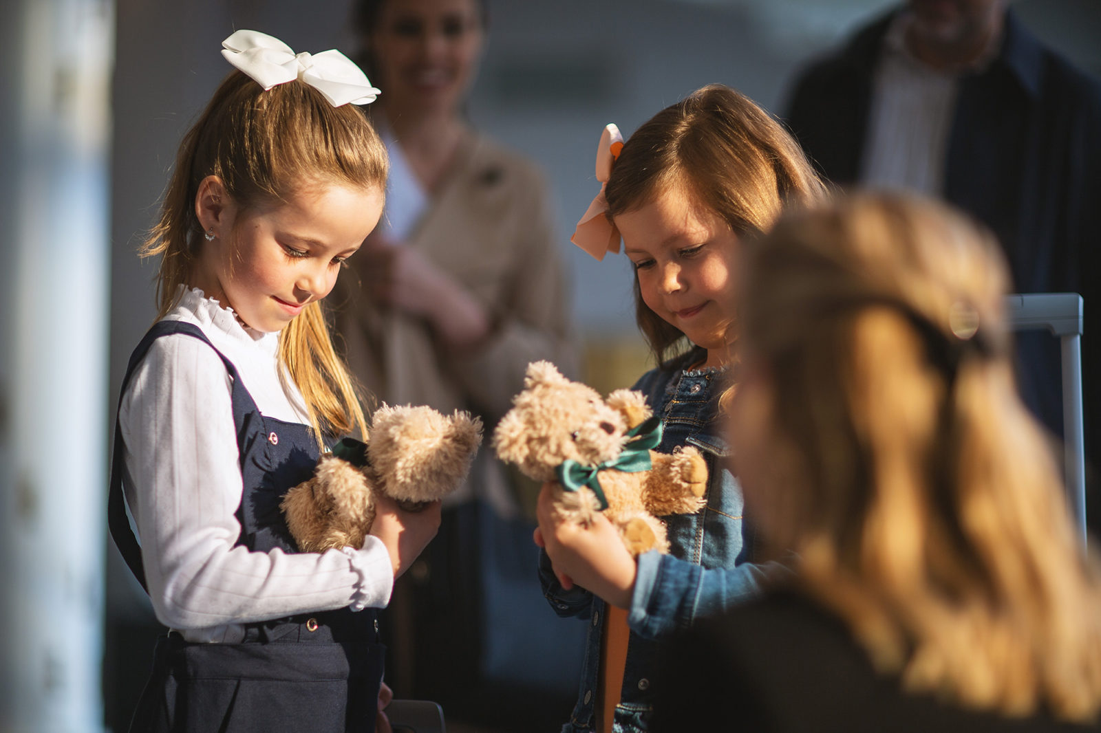 To jenter som mottar bamser ved ankomst på Britannia