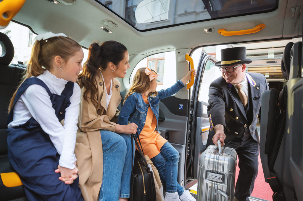 Familie som ankommer Britannia Hotel i Trondheim med London taxi